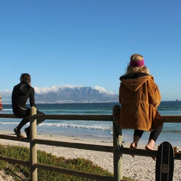 a person sitting on a bench next to a body of water