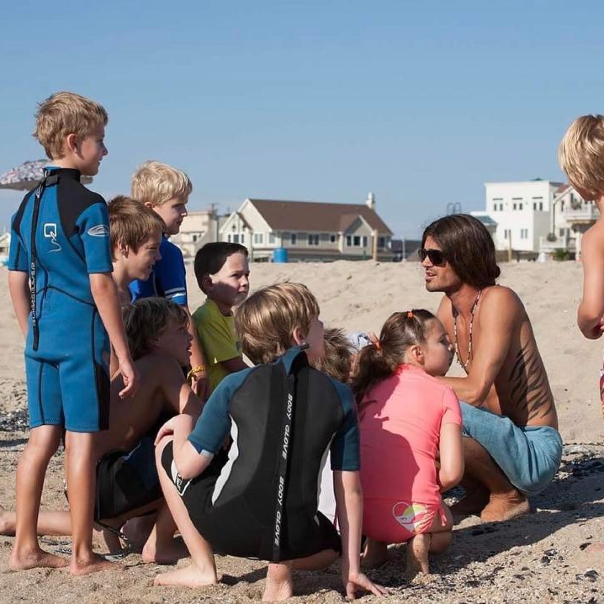 a group of people standing on top of a sandy beach