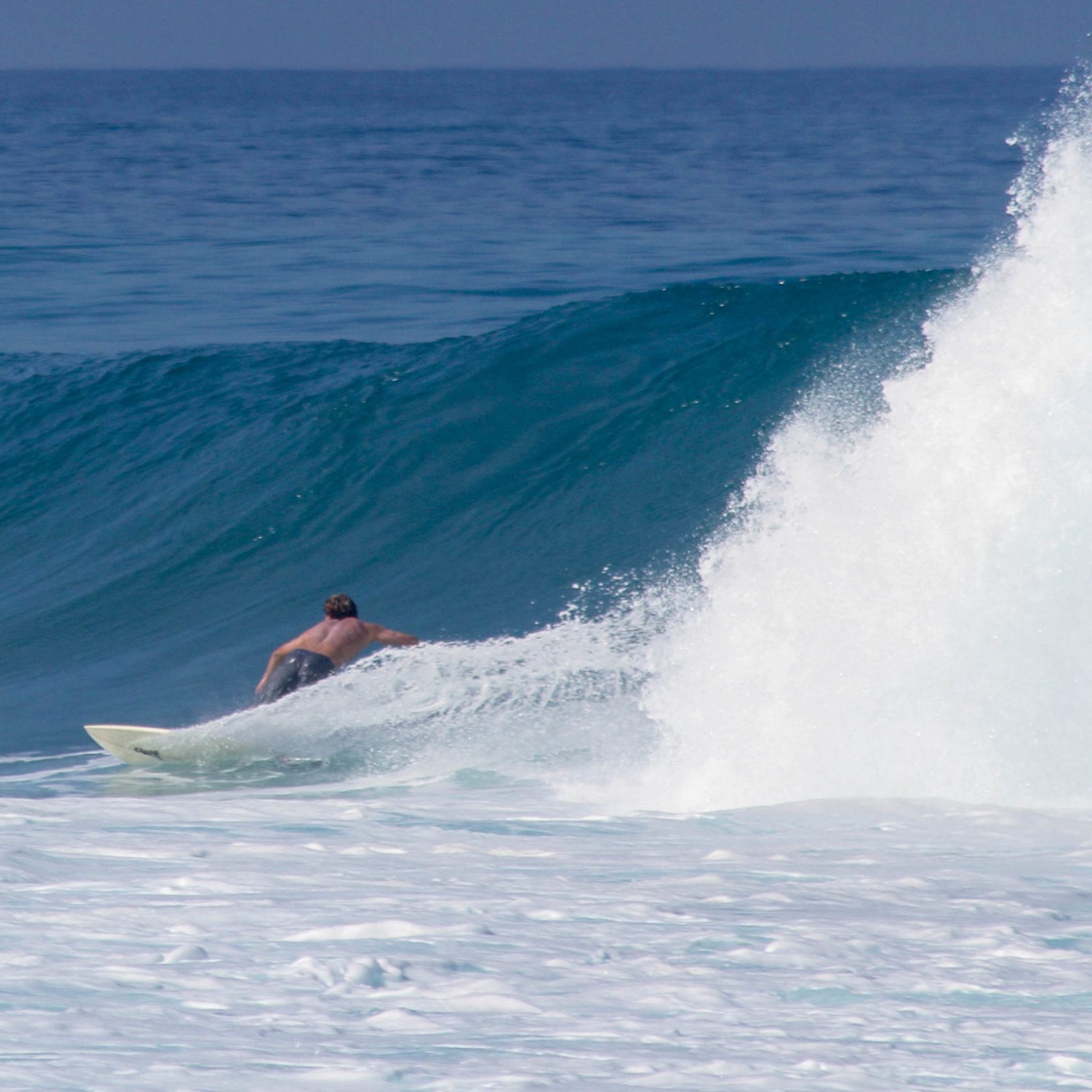 a man riding a wave on a surfboard in the ocean