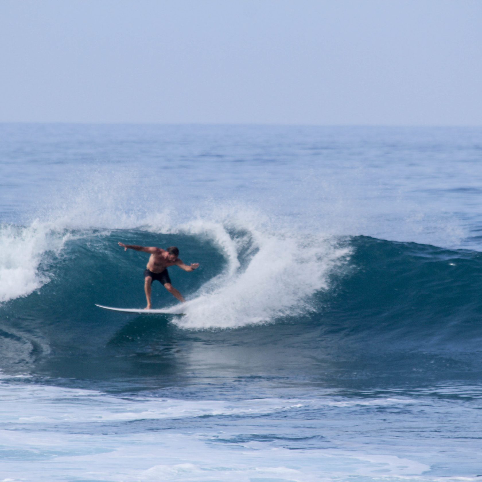 a man riding a wave on a surfboard in the ocean