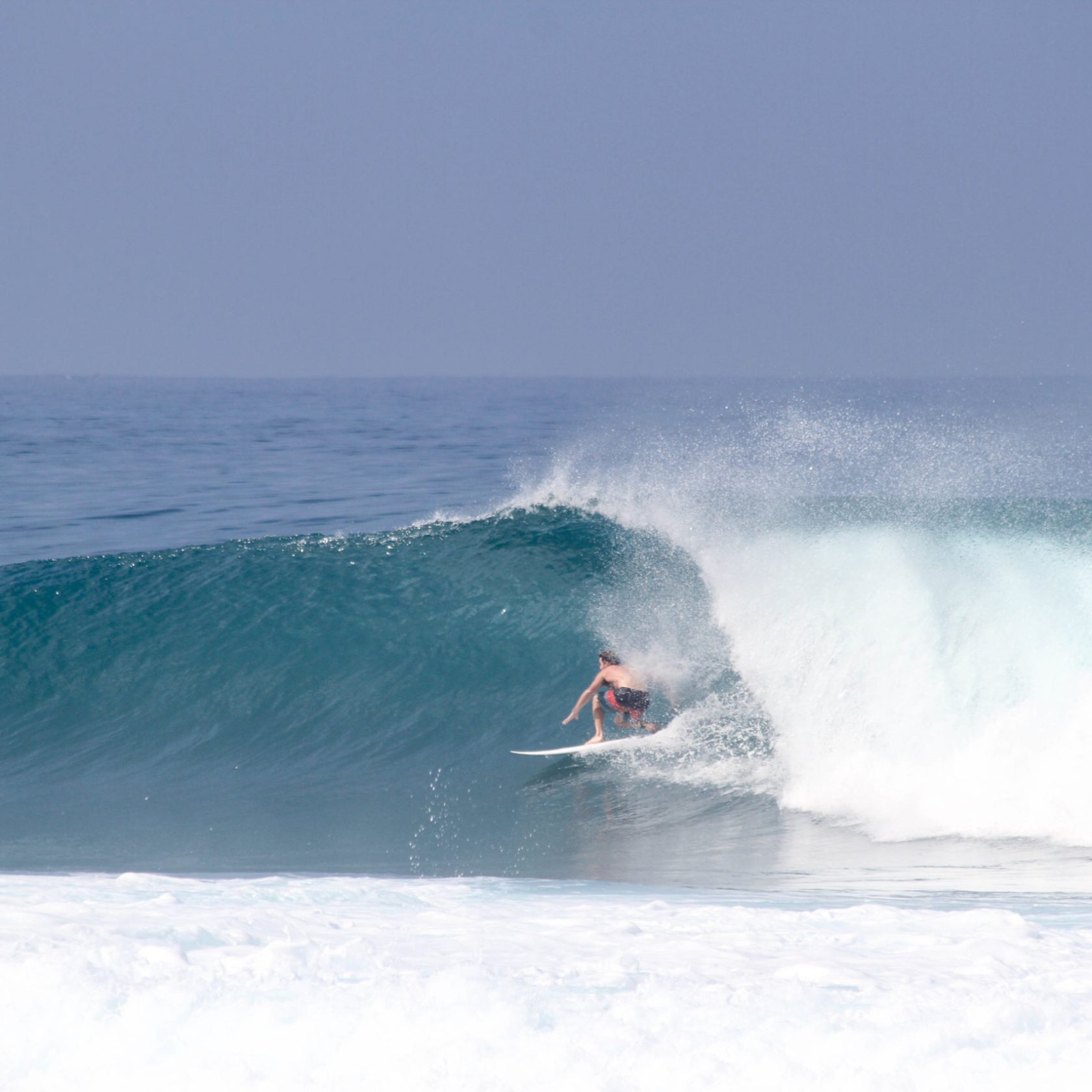 a man riding a wave on a surfboard in the ocean