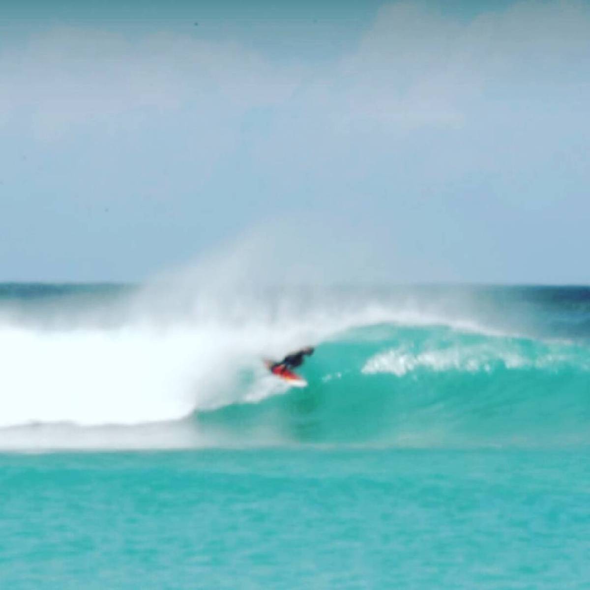 a man flying through the air while riding a wave in the ocean