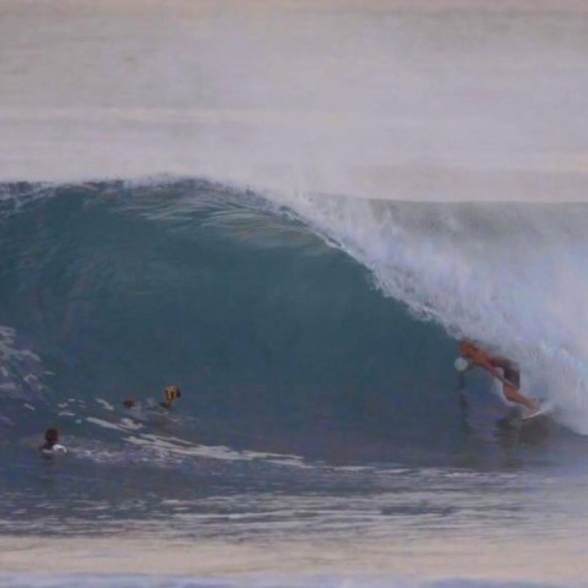 a man riding a wave on a surfboard in the water