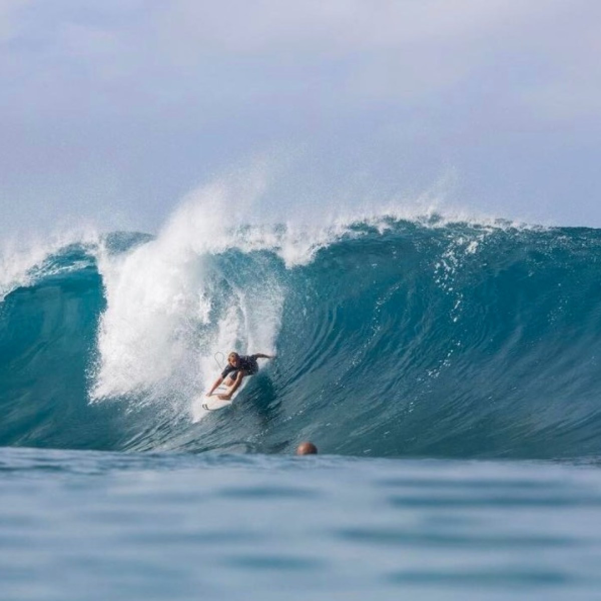 a man riding a wave on a surfboard in the ocean