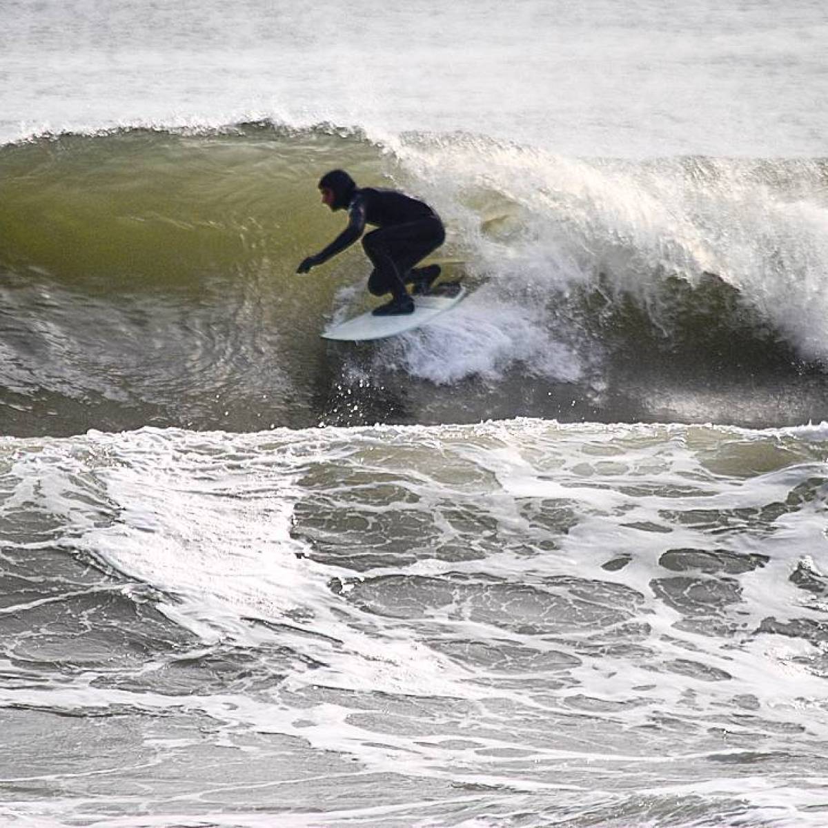 a man riding a wave on a surfboard in the ocean