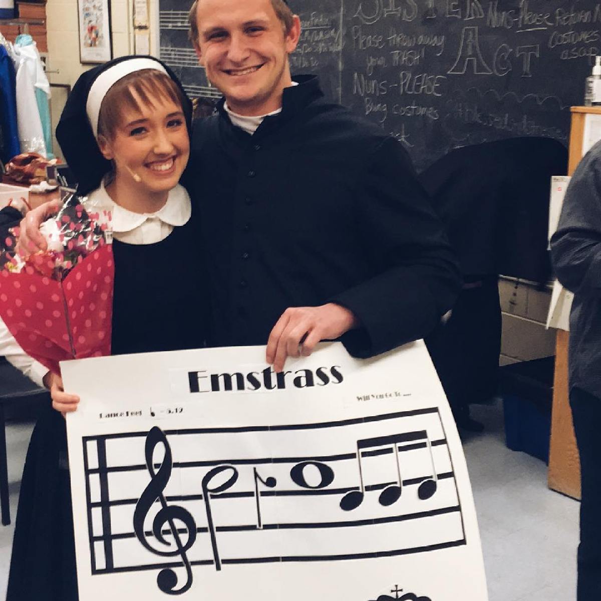 a person holding a sign posing for the camera