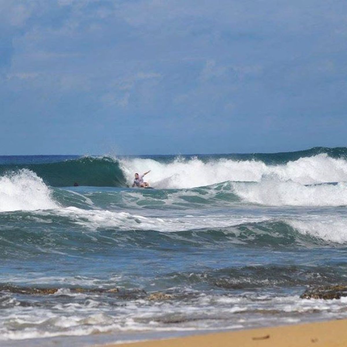a man riding a wave on a surfboard in the ocean