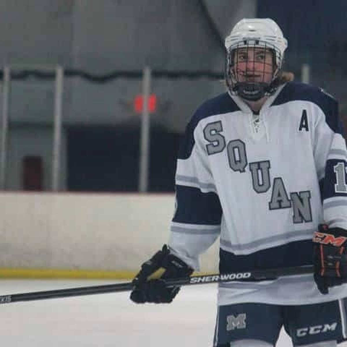 a hockey player holding a baseball bat
