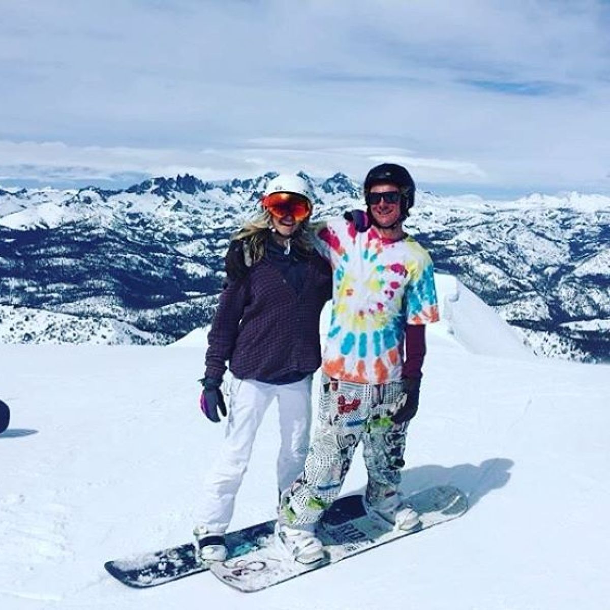 a man riding a snowboard down a snow covered slope