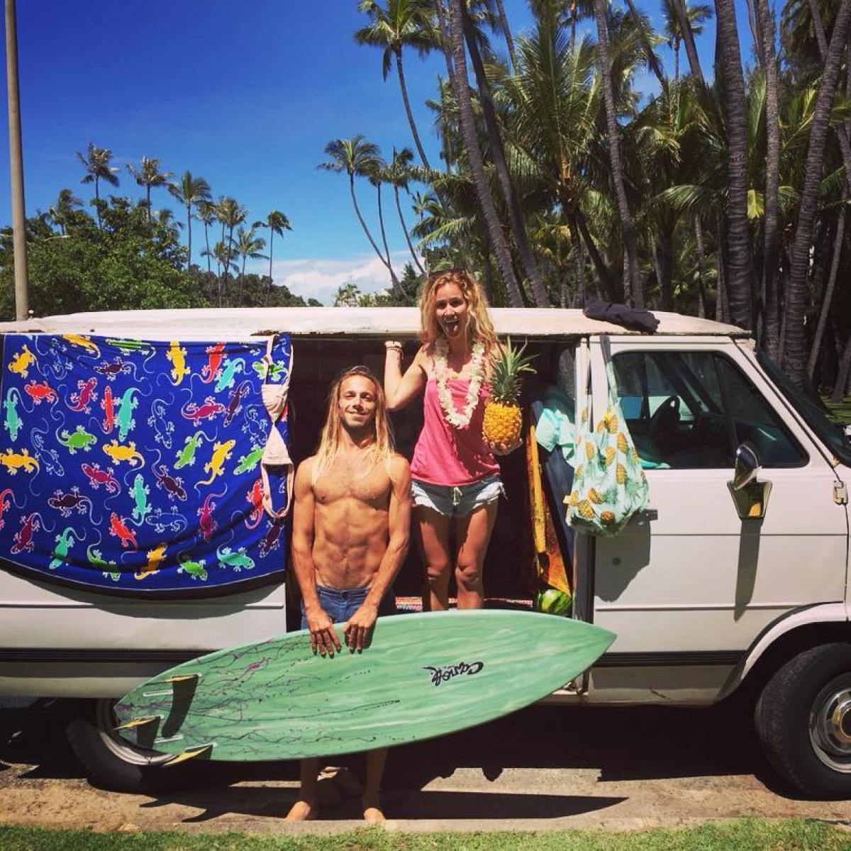 a person standing in front of a green truck parked in a parking lot
