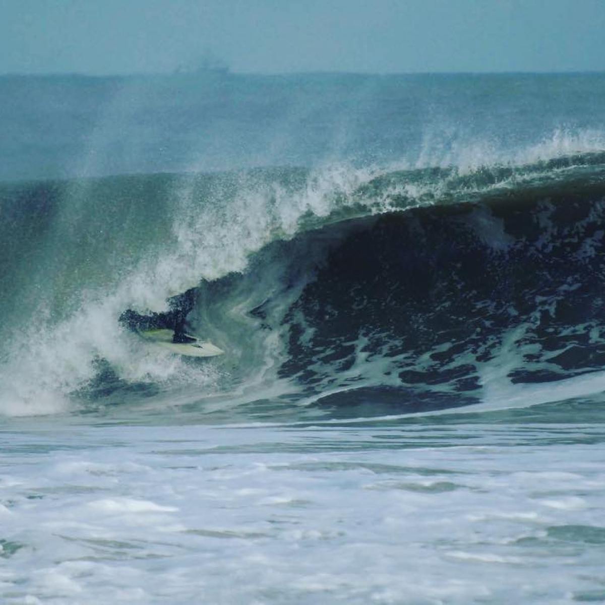 a man riding a wave on a surfboard in the ocean