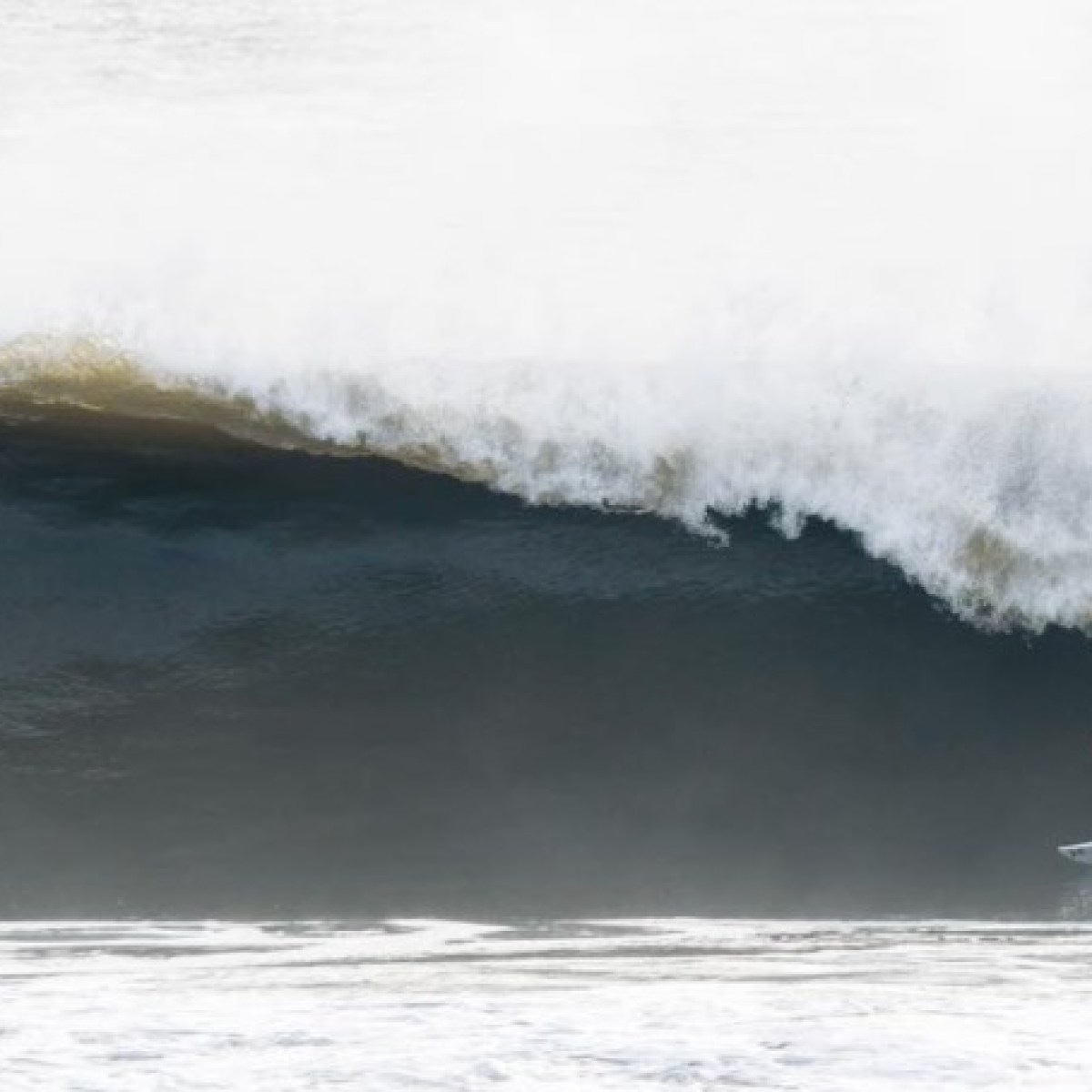 a man riding a wave on a surfboard in the ocean