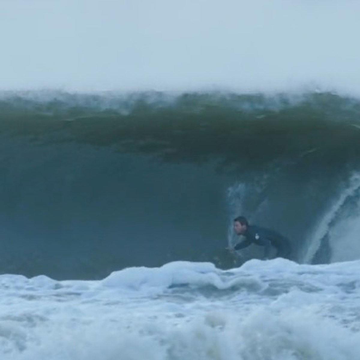 a man riding a wave on a surfboard in the water