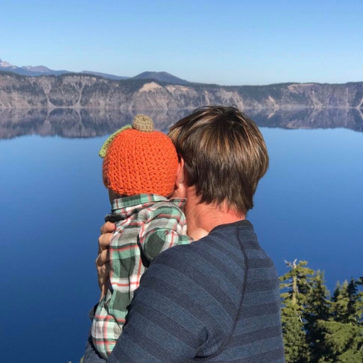 a young boy standing in front of a mountain