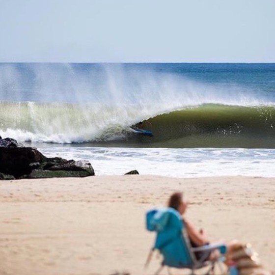 a person riding a wave on top of a sandy beach