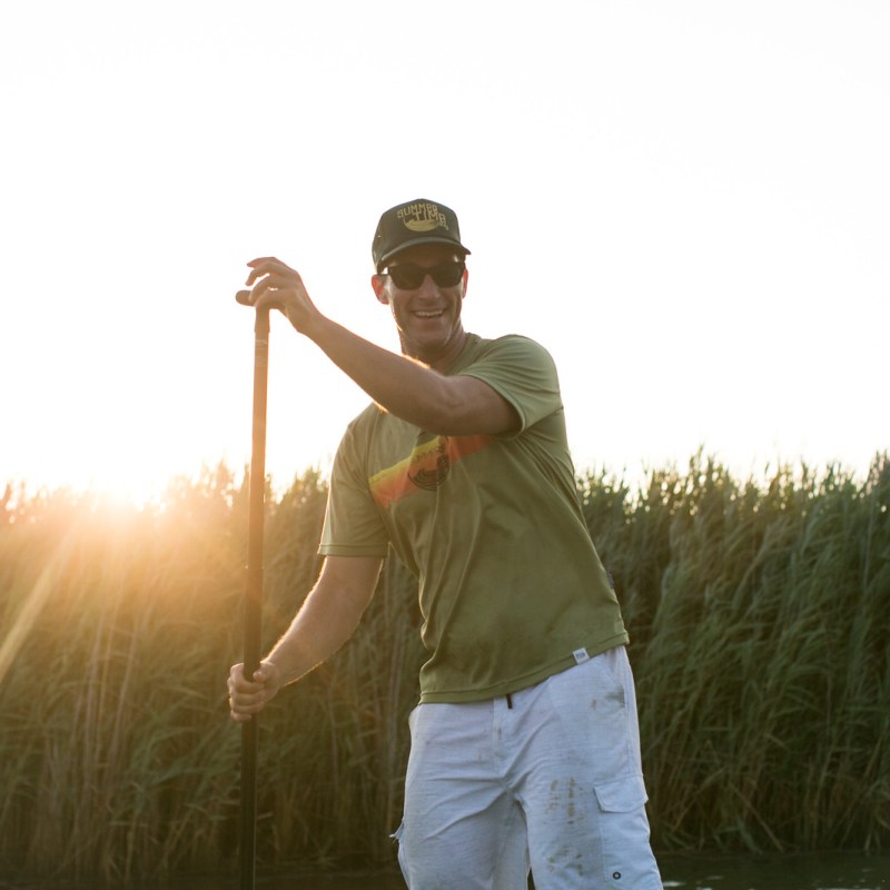 a man standing on top of a grass covered field