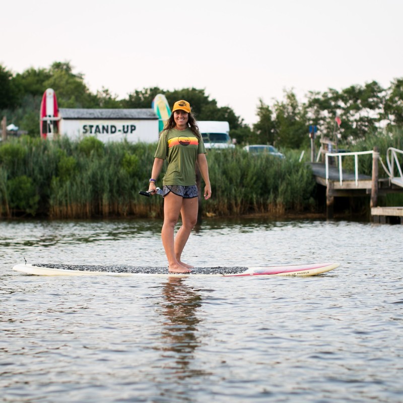 a little girl riding on the back of a boat in the water