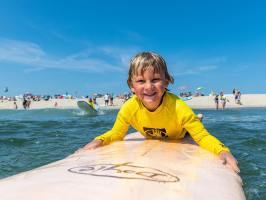 a young man riding a surfboard in the water