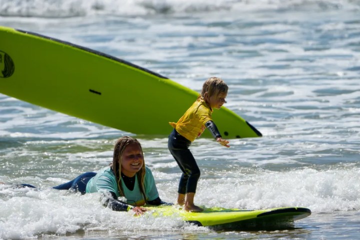 a young girl riding a wave on a surfboard in the water