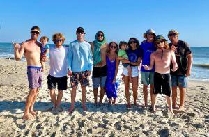 a group of people standing on a beach posing for the camera