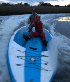 a person standing next to a body of water with boats in the snow