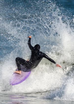 a young girl riding a wave on a surfboard in the ocean