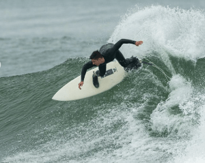 a man wearing a wet suit riding a wave in the ocean