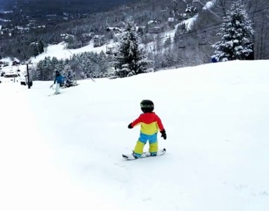 a man riding a snowboard down a snow covered slope