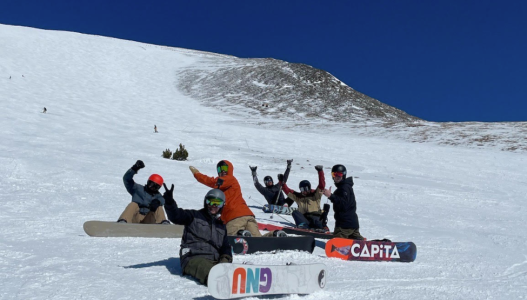 a group of people sitting on a snow board