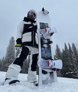 a man riding a snowboard down a snow covered slope