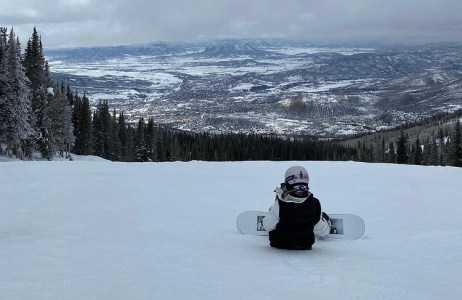 a man sitting on top of a snow covered slope