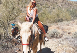 a person riding a horse on a dirt road