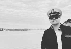 a person wearing a hat standing next to a body of water