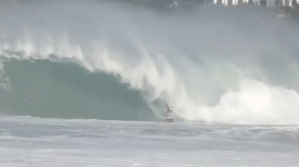 a man riding a wave on a cloudy day