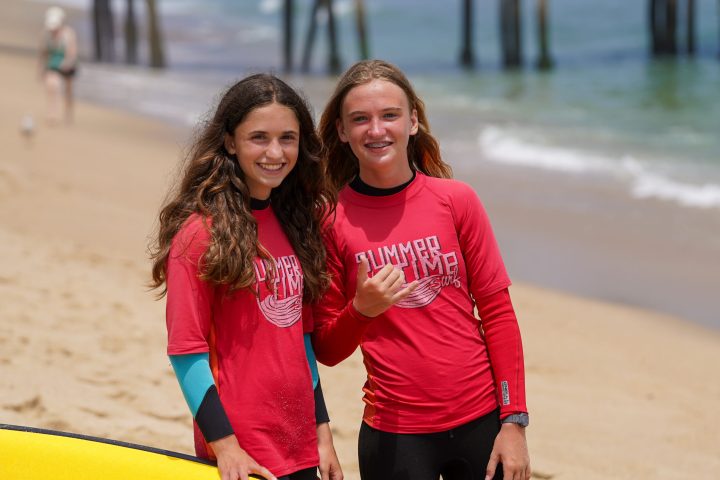 a little girl that is standing in the sand on a beach