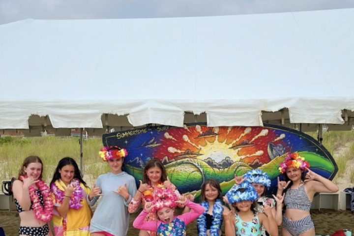 a group of people standing next to a little girl posing for a picture