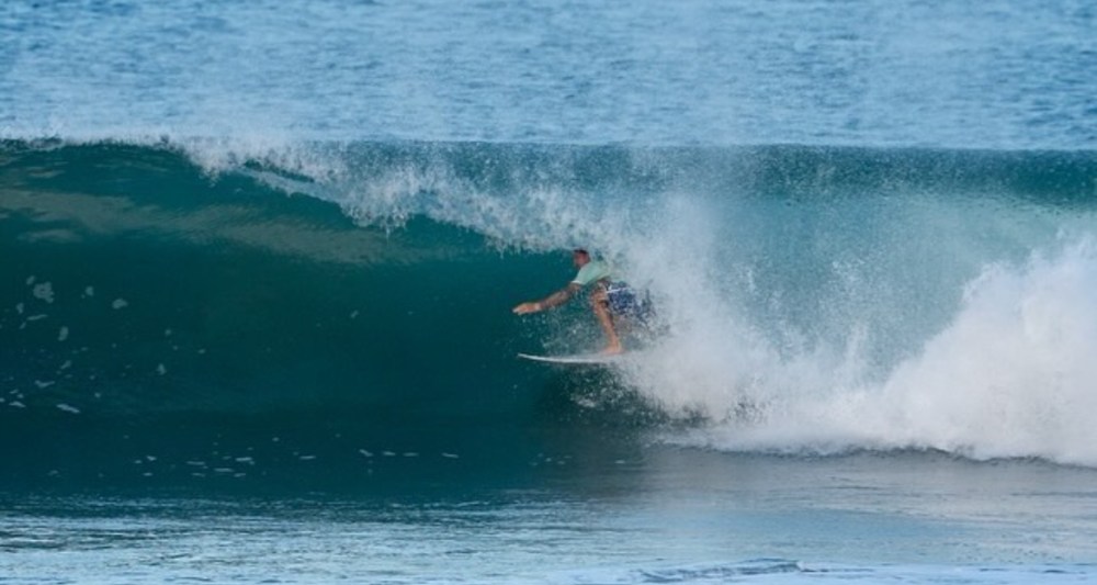 a man riding a wave on a surfboard in the ocean