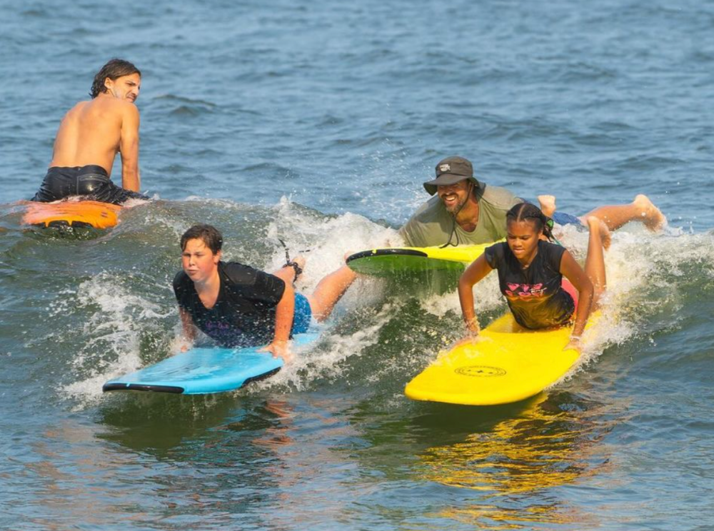 a small girl riding a wave on a surfboard in the water