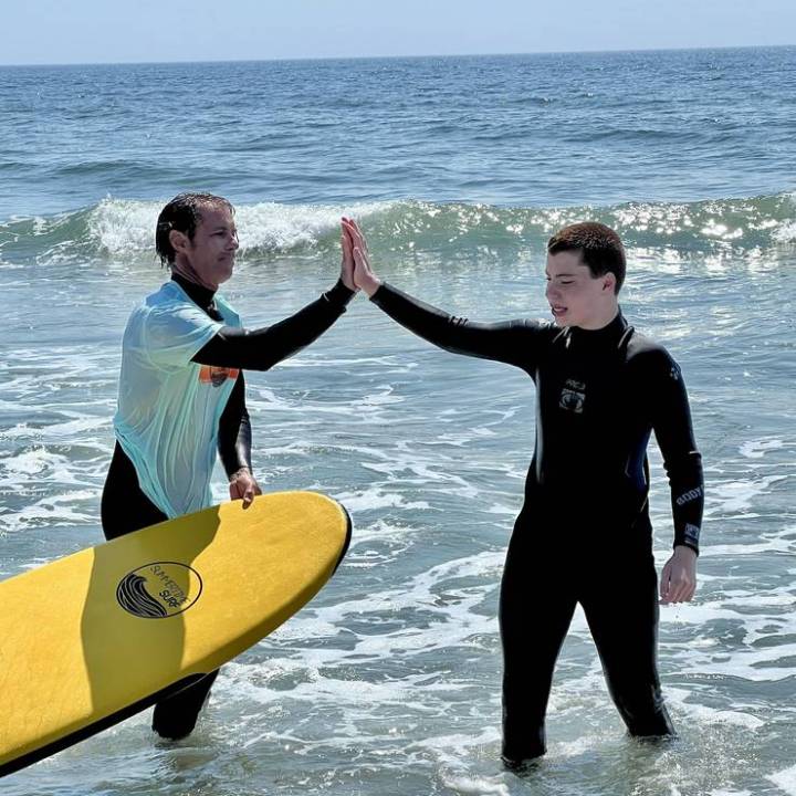 a man standing next to a body of water
